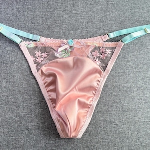 Puede incluir: Ropa interior de satén rosa y encaje con un lazo azul y bordado floral.