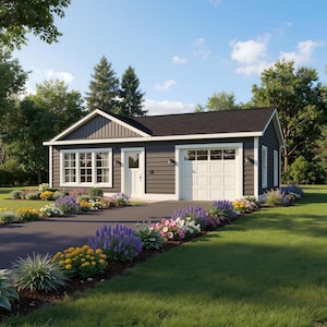 May include: A small, dark gray house with a white garage door and trim. The house has a black roof and is surrounded by a lush green lawn and colorful flower beds. A paved driveway leads to the garage.