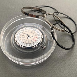 Pu&ograve; includere: Un set di tre tazze in ceramica con finitura opaca e macchiettata. Le tazze sono nei toni del crema, grigio chiaro e grigio scuro. Ogni tazza ha un design semplice e minimalista e un manico arrotondato.