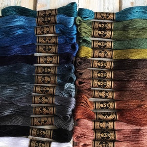 May include: A collection of 40 spools of DMC embroidery floss in various shades of blue, green, brown, beige, and white. Each spool is labeled with the DMC color number and the text "DMC - Moulin&eacute; Special - 25m (8.7 yds)".