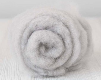 May include: A close-up of a roll of light gray wool roving. The wool is soft and fluffy, and it is perfect for felting or spinning.