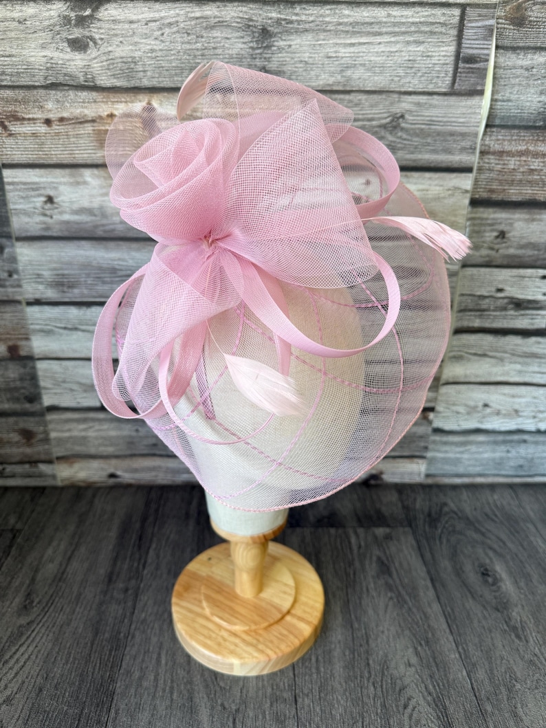 May include: A white ceramic mug with a black handle and the text "But First, Coffee" in a black, bold font. The mug is on a white surface. The mug is approximately 10 cm tall.