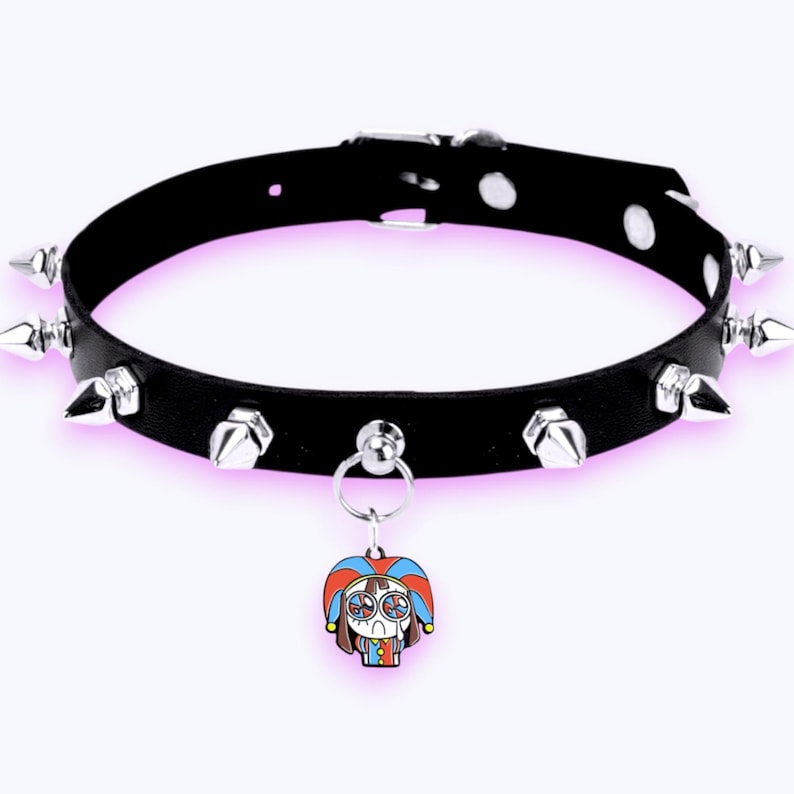May include: A black choker necklace featuring silver-toned metal spikes arranged along the band. The choker includes a central silver ring holding a small, colorful enamel charm depicting a cartoon character wearing a jester hat in red and blue.