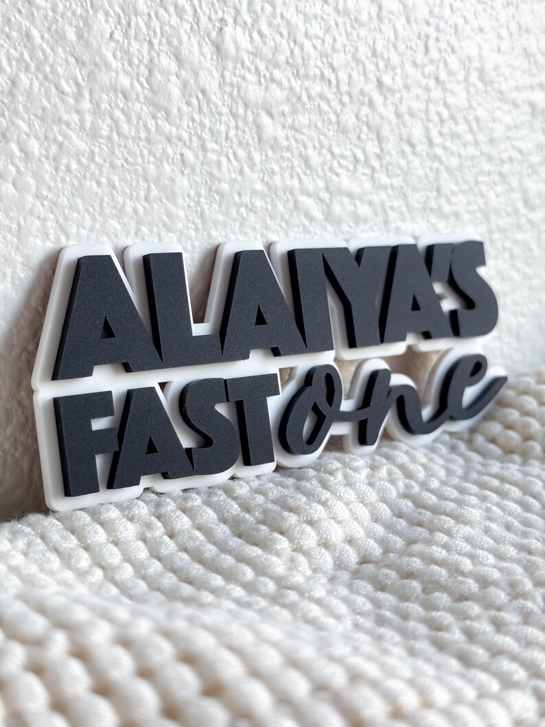 May include: Black and white sign with the text "Alaiya's Fast & Furious" in a bold, stylized font.