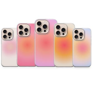 Può includere: Cinque custodie per telefoni con un design sfumato nei toni del rosa, arancione e bianco. Le custodie hanno un bordo trasparente e un ritaglio per la fotocamera. Le custodie sono disposte in fila, mostrando le variazioni di colore.