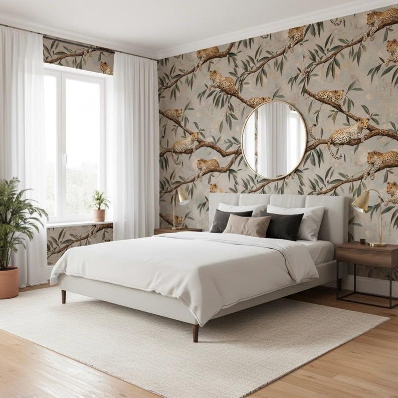 K&ouml;nnte beinhalten: Ein Schlafzimmer in neutralen Farbt&ouml;nen, mit einem Bett mit wei&szlig;er Bettdecke und Kissen. Die Tapete zeigt ein Leopardenmuster. Ein runder Spiegel und Nachttische mit Lampen erg&auml;nzen die Einrichtung.