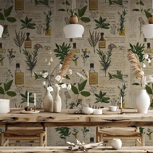 May include: A rustic dining room with a wooden table and chairs. The walls are covered in a beige wallpaper with a botanical print featuring various herbs and flowers. The wallpaper has a vintage, antique look.