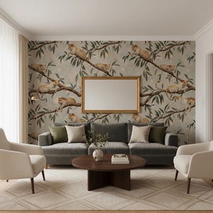 K&ouml;nnte beinhalten: Ein Wohnzimmer mit grauem Sofa, zwei cremefarbenen Sesseln und einem runden Couchtisch aus Holz. Der Blickfang ist eine Wand mit Tapeten, die Leoparden auf &Auml;sten zeigen, erg&auml;nzt durch einen goldgerahmten Spiegel.