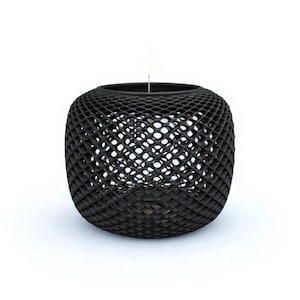 Puede incluir: Una linterna decorativa negra, esférica, de tejido abierto. La linterna tiene una forma redondeada con un diseño de celosía, creando un patrón de aberturas en forma de diamante. Está suspendida por un fino alambre sobre un fondo blanco.