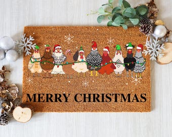 May include: A rectangular doormat with a brown coir surface. The mat features a festive design of cartoon chickens wearing Santa hats and string lights, with the words "MERRY CHRISTMAS" in black. Decorative snowflakes are scattered around the chickens.