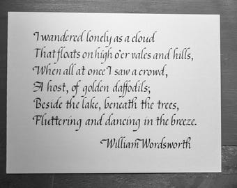 May include: A white card with a poem written in elegant black calligraphy. The poem, by William Wordsworth, begins "I wandered lonely as a cloud." The text is centered on the card, with a simple, classic aesthetic.