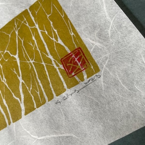 Op de afbeelding: Een gouden en witte print van een bos scène op getextureerd papier. De print is gesigneerd "A. Stone 1989" en heeft een rode stempel in de rechter benedenhoek.