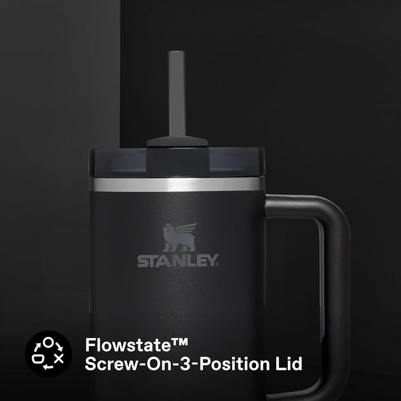 K&ouml;nnte beinhalten: Ein schwarzer Stanley Flowstate-Becher mit Schraubdeckel und Griff. Der Becher tr&auml;gt das Stanley-Logo und den Text "Flowstate Screw-On-3-Position Lid". Der Becher hat einen Strohhalm und ist f&uuml;r Getr&auml;nke konzipiert.
