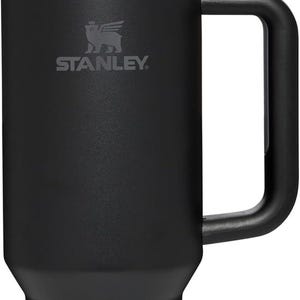 K&ouml;nnte beinhalten: Schwarzer Stanley Quencher H2.0 FlowState Becher mit Griff und wiederverwendbarem Strohhalm. Der Becher hat das Stanley-Logo auf der Vorderseite. Er ist so konzipiert, dass Getr&auml;nke stundenlang kalt bleiben.