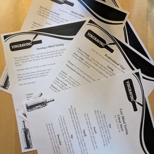 May include: A collection of printed instruction sheets for wine tasting, featuring the "VINGRAVING" logo and detailed guides on blind tasting techniques. The sheets include sections on concealment, professional tips, and a cheat sheet, all printed in black ink.