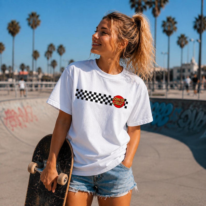 Puede incluir: Una camiseta blanca de manga corta con un patr&oacute;n de cuadros negros y blancos horizontal en el pecho, acentuada por un logotipo circular rojo con el texto Santa Cruz impreso en letras blancas, combinada con pantalones cortos de mezclilla.