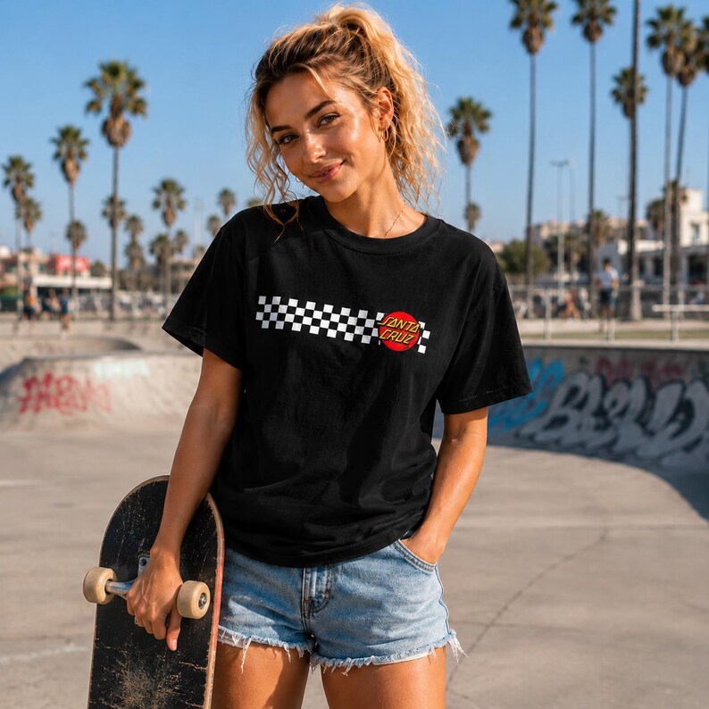 Puede incluir: Una camiseta negra de manga corta con un patr&oacute;n de cuadros blanco y negro horizontal en el pecho, acentuado por un logotipo circular rojo con el texto Santa Cruz impreso en letras amarillas en el lado derecho del gr&aacute;fico.