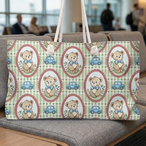 May include: A large tote bag with a repeating pattern of teddy bears in oval frames and blue toy cars on a green and white checkered background. The bag has white rope handles.