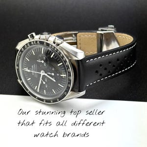 May include: A silver-toned wristwatch with a black face and a black leather strap with white stitching. The watch face has multiple dials and the word "OMEGA" is visible. The text on the image reads "Our stunning top seller that fits all different watch brands."