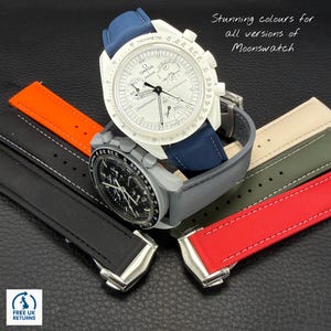 May include: Two Omega Swatch Speedmaster watches with white and black faces, displaying watch straps in blue, orange, black, green, and red. The text reads "Stunning colours for all versions of Moonswatch."