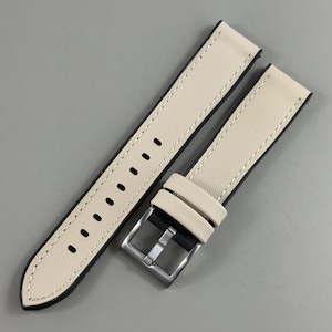 May include: Cream-colored watch strap with black backing and white stitching. The strap features a stainless steel buckle and multiple adjustment holes. The watch band is made of a textured canvas material.