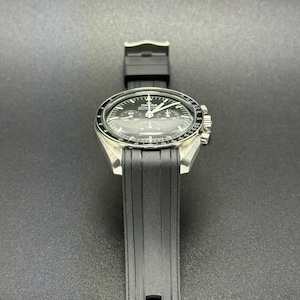 Puede incluir: Un reloj de pulsera plateado con esfera negra y correa de caucho negra. El reloj tiene una esfera redonda con agujas y marcadores blancos. El reloj es de dise&ntilde;o cl&aacute;sico.