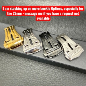 Puede incluir: Cuatro hebillas de reloj en oro, plata, negro y metal de ca&ntilde;&oacute;n. Las hebillas se muestran sobre una superficie oscura. El texto en la parte superior dice: "I am stocking up on more buckle Options, especially for the 22mm - message me if you have a request not available."
