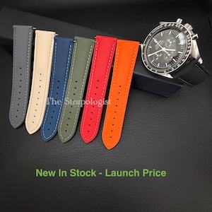 Puede incluir: Una colecci&oacute;n de correas de reloj coloridas en gris, crema, azul, verde oliva, rojo y naranja, con costuras blancas. Un reloj negro con bisel plateado se muestra. El texto "The Strapologist" es visible.