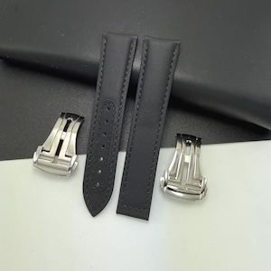 May include: Black watch straps with a textured finish and contrasting stitching. Two silver-coloured clasps are also included. The watch straps are made of a durable material and designed for a comfortable fit.