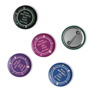 Op de afbeelding: Een verzameling ronde buttons in verschillende kleuren, waaronder zwart, paars en blauw. Elke button bevat de tekst "Never, NOT ONCE, Did I VOTE For him." en andere zinnen zoals "Too Smart" en "Too Loving."