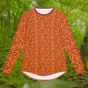 Peut inclure: Chemise à manches longues orange avec un motif de serpent brun.