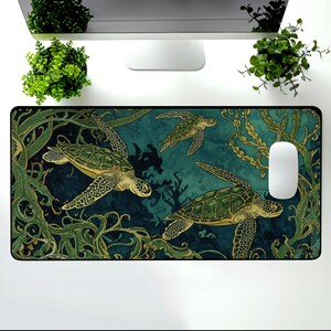 May include: A rectangular mouse mat with a teal and green underwater design, featuring three sea turtles. The turtles have green and brown patterns, surrounded by seaweed and coral. A white computer mouse is on the right.