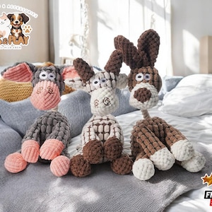 May include: Three plush dog toys in the shape of animals. The toys are brown, grey, and white with pink accents. The toys are on a grey blanket.