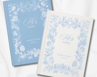 May include: Two wedding vow books. One is light blue with "His Vows" and floral design. The other is white with "Her Vows" and a similar floral design. Both books have the names "Elodie & Louis" and the date "06.16.2026".