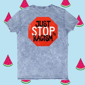 Puede incluir: Una camiseta azul claro con un gráfico de señal de stop roja que dice "JUST STOP RACISM" en texto negro.