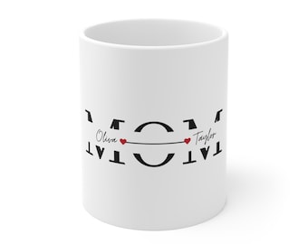 Könnte beinhalten: Weiße Keramik-Tasse mit dem Wort "MOM" in Schwarz, mit den Namen "Olivia" und "Taylor" auf beiden Seiten, verbunden durch eine Linie mit roten Herz-Akzenten. Ein personalisiertes Geschenk.