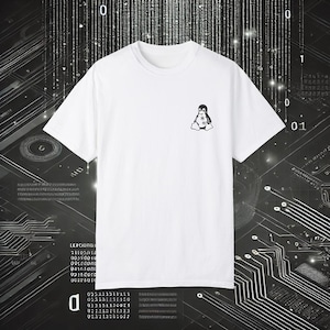 Può includere: Maglietta bianca con una grafica di pinguino in bianco e nero. Il pinguino indossa un cappello e ha un piccolo sorriso. La maglietta è su uno sfondo bianco e nero con un motivo di linee e numeri.