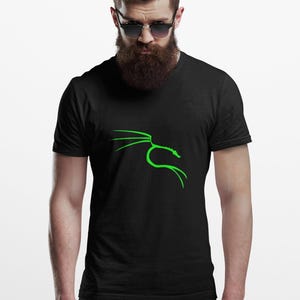 May include: Black t-shirt featuring a green stylized dragon design. The graphic is a simple outline of a dragon with a curved body and outstretched wings. The shirt is a classic crew neck style.