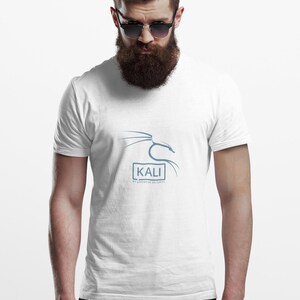 May include: White t-shirt featuring the word "KALI" in a blue font, with a stylized graphic above and the text "BY OFFENSIVE SECURITY" below. The shirt is worn by a person with a beard and sunglasses.