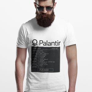 以下が含まれることがあります： 黒いグラフィックプリントが施された白い半袖Tシャツ。デザインにはPalantirのロゴと、GOTHAM、MISSION MODE、SEE THE INVISIBLE. DO THE IMPOSSIBLE.というテキストが書かれたターミナルスタイルのコマンドラインインターフェースが含まれています。