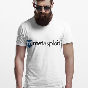 May include: White t-shirt with the word "metasploit" printed in black and a blue logo. The shirt is plain and has short sleeves. The model is wearing sunglasses and black pants.