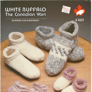 Op de afbeelding: Een breipatroon voor pantoffels gemaakt met White Buffalo The Canadian Yarn. Het patroon bevat vier paar pantoffels in verschillende kleuren en patronen, waaronder wit, grijs en roze.