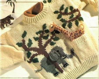 May include: Cream-colored knitted sweater with a brown tree and elephant design. The sweater features a giraffe in the pocket and green buttons. The text "Tiny Treasures" is visible at the top.