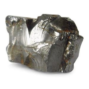 Puede incluir: Una roca rugosa, gris y metálica con una forma irregular y dentada.