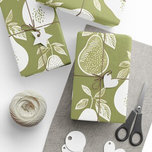 May include: Three green gift boxes wrapped in pear-patterned paper with white pear illustrations. The boxes are tied with brown twine and decorated with white paper stars and hearts.