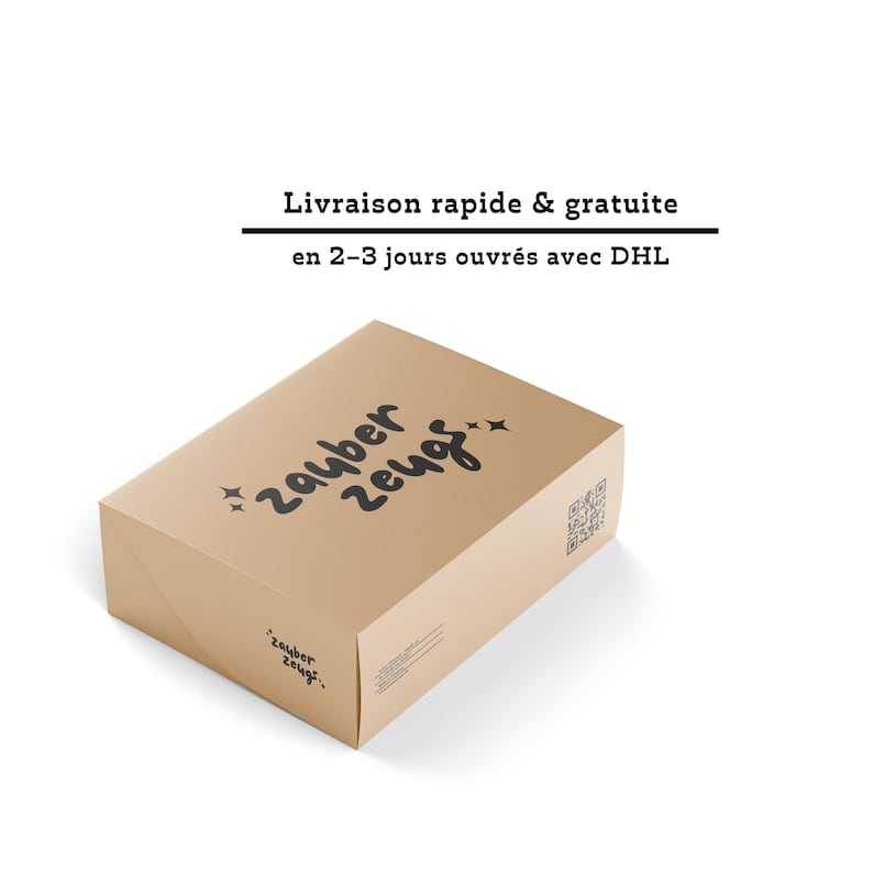 May include: A brown cardboard box with the words "zauber zeug" in black script and star accents. The box has a QR code and additional text on the side. The top of the box has the words "zauber zeug" in black script.