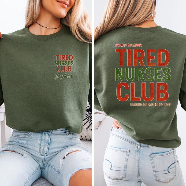 May include: An olive green sweatshirt with the text "Tired Nurses Club" in red and green. The front of the sweatshirt has the name "Sophia" below the text. The back of the sweatshirt has the text "Proud Member" above the text "Tired Nurses Club" and "Running on Caffeine & Chaos" below.