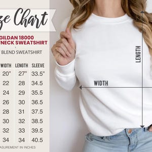 May include: White Gildan 18000 crewneck sweatshirt with a size chart. The size chart shows measurements in inches for width, length, and sleeve length, ranging from size S to 5XL. The sweatshirt is a heavy blend.