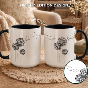 May include: Two white ceramic mugs with black interiors and handles, featuring a black dandelion graphic with seeds blowing in the wind. The text LIMITED EDITION DESIGN and TOP SELLER appear above the mugs, with a circular inset showing detail.