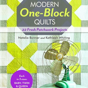 Op de afbeelding: Een boek getiteld Modern One-Block Quilts: 22 Fresh Patchwork Projects door Natalia Bonner en Kathleen Whiting, met een limoengroene en witte quiltachtergrond en een vintage metalen bureauventilator op een ronde tafel op de voorgrond.